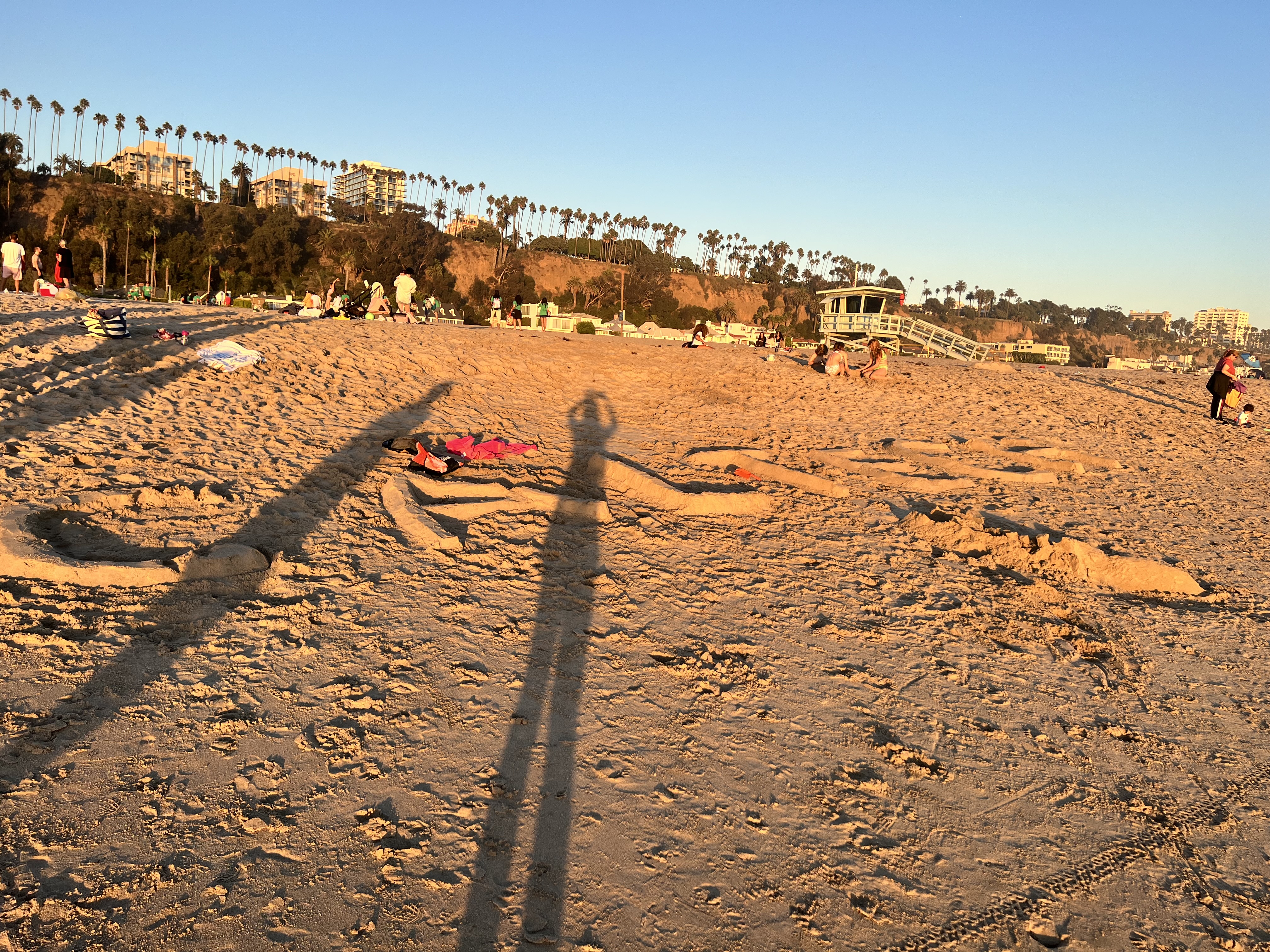 The words "Caltech" displayed in sand at an Admissions beach event.